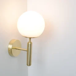 Applique murale avec globe en verre opalin et support doré douille E27 idéale pour chambre salon et couloir.