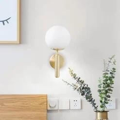 Applique murale avec globe en verre opalin et support doré douille E27 idéale pour chambre salon et couloir.